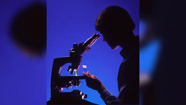 A person at a microscope in an illustrative laboratory photograph