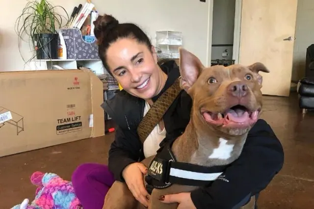 Woman holding a brown dog