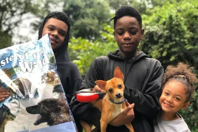 Young people with a small dog and donated supplies