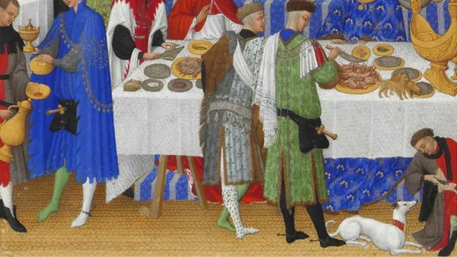 A banquet scene with a pale dog lying near the diners