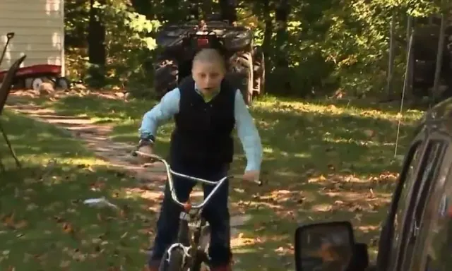 Landin riding his bicycle through the yard