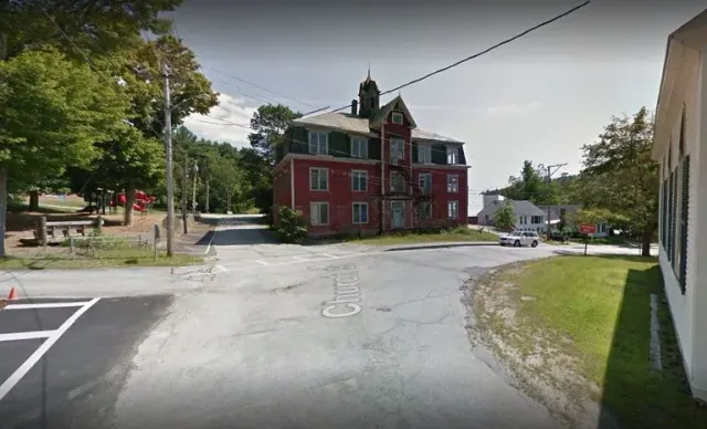 Red brick building beside a street in Warner
