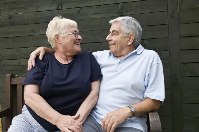 Two older adults seated together outside