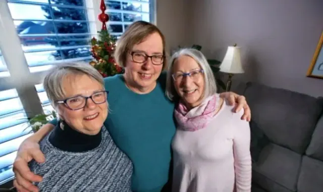 Three women standing together in a living room