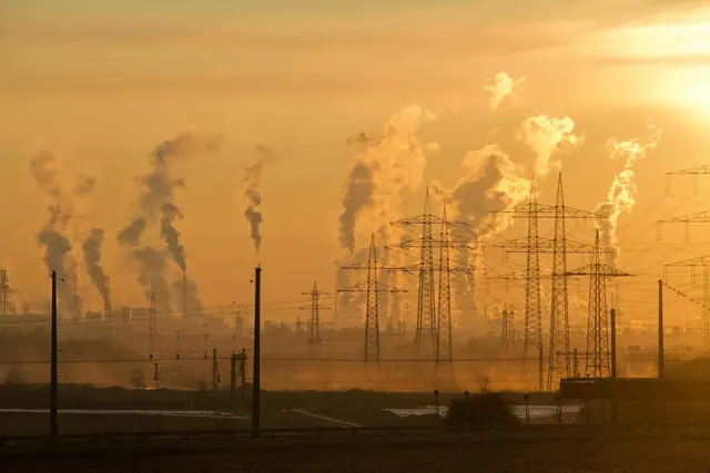 Industrial emissions at sunset, illustrating climate pressures