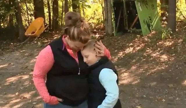 Hope embracing Landin outdoors