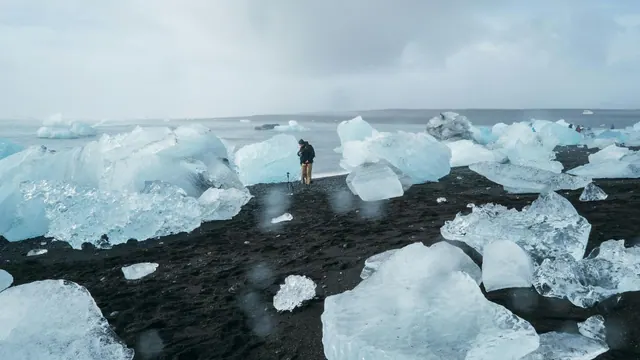 A person standing among coastal ice, an illustrative photograph