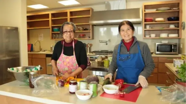 Two residents preparing food in a kitchen