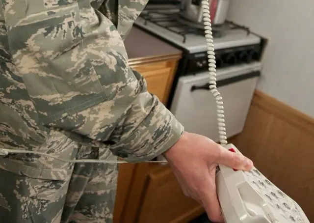 Illustrative photograph of a person using a telephone