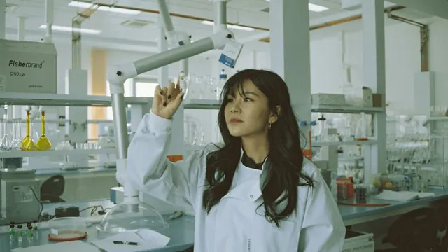 A person examining a vial in an illustrative laboratory photograph