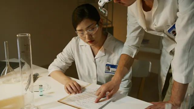 Researchers sitting at a lab bench looking at paperwork.