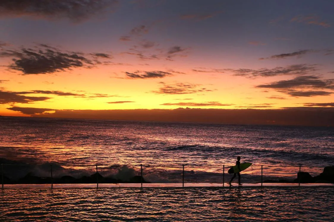 A surfer heads out at Bronte Beach in Sydney, Australia