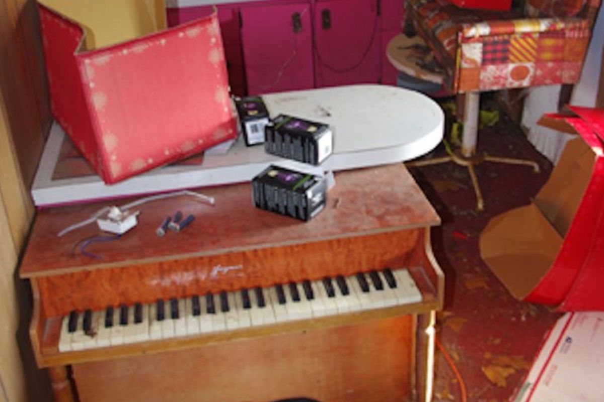 An upright piano, small table and chairs inside the playhouse.