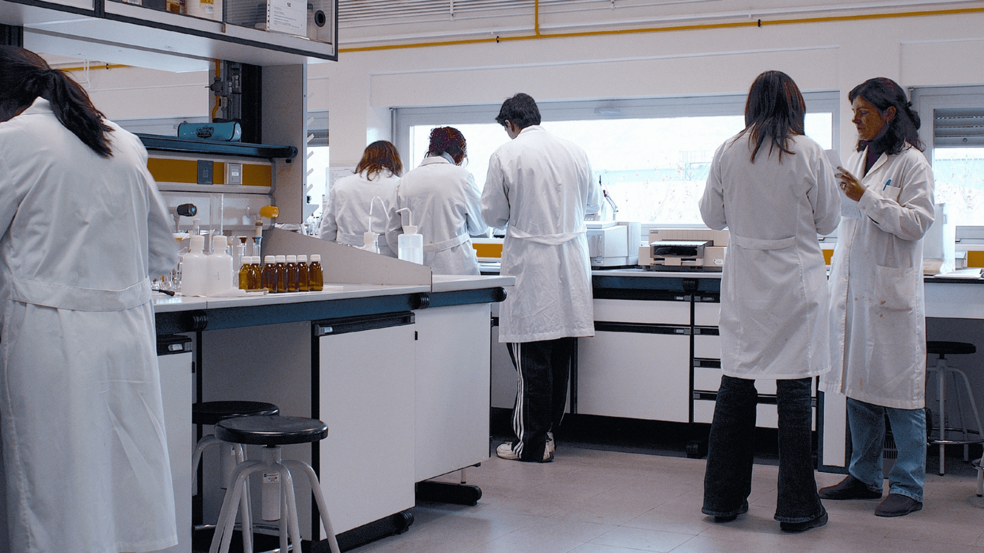 An illustrative photograph of people in white coats in a laboratory.