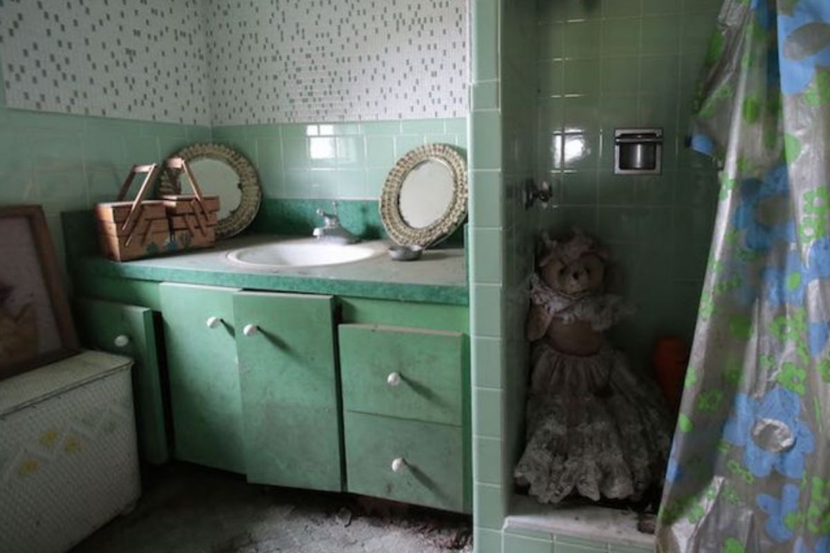 A green bathroom vanity and curtained shower inside the playhouse.