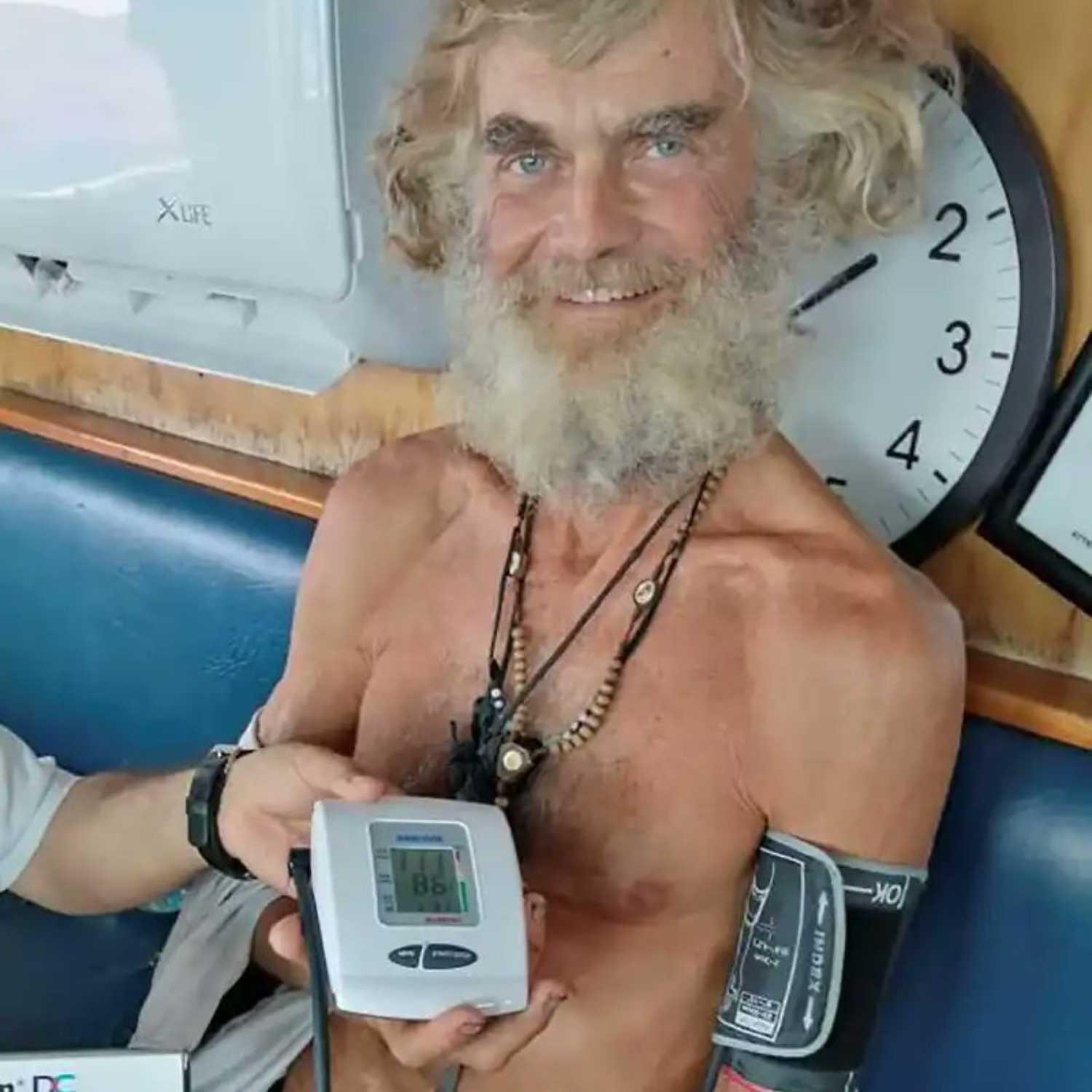 Tim Shaddock holding equipment aboard a vessel.