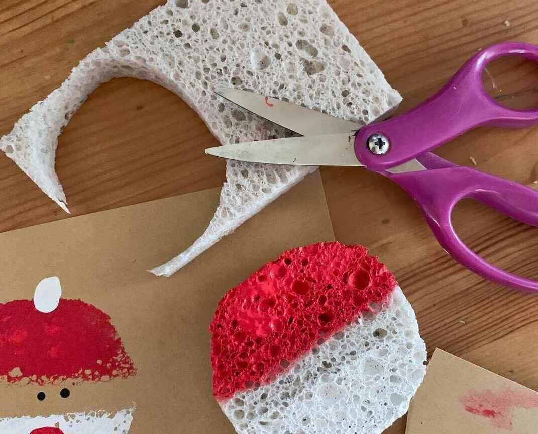 Cut sponge shapes with red and white paint beside scissors.