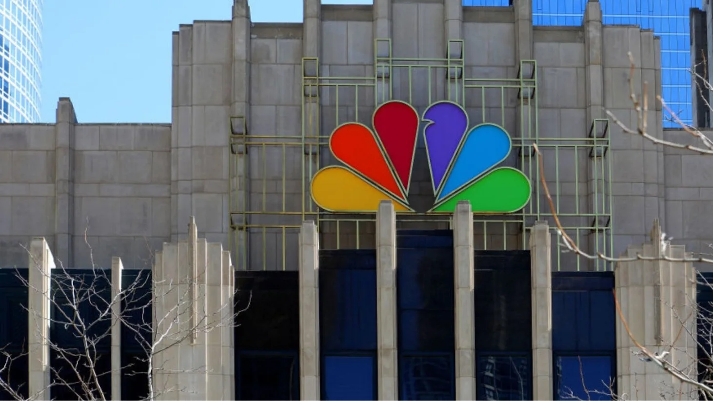 The colorful peacock logo of NBC prominently displayed on the exterior of a building