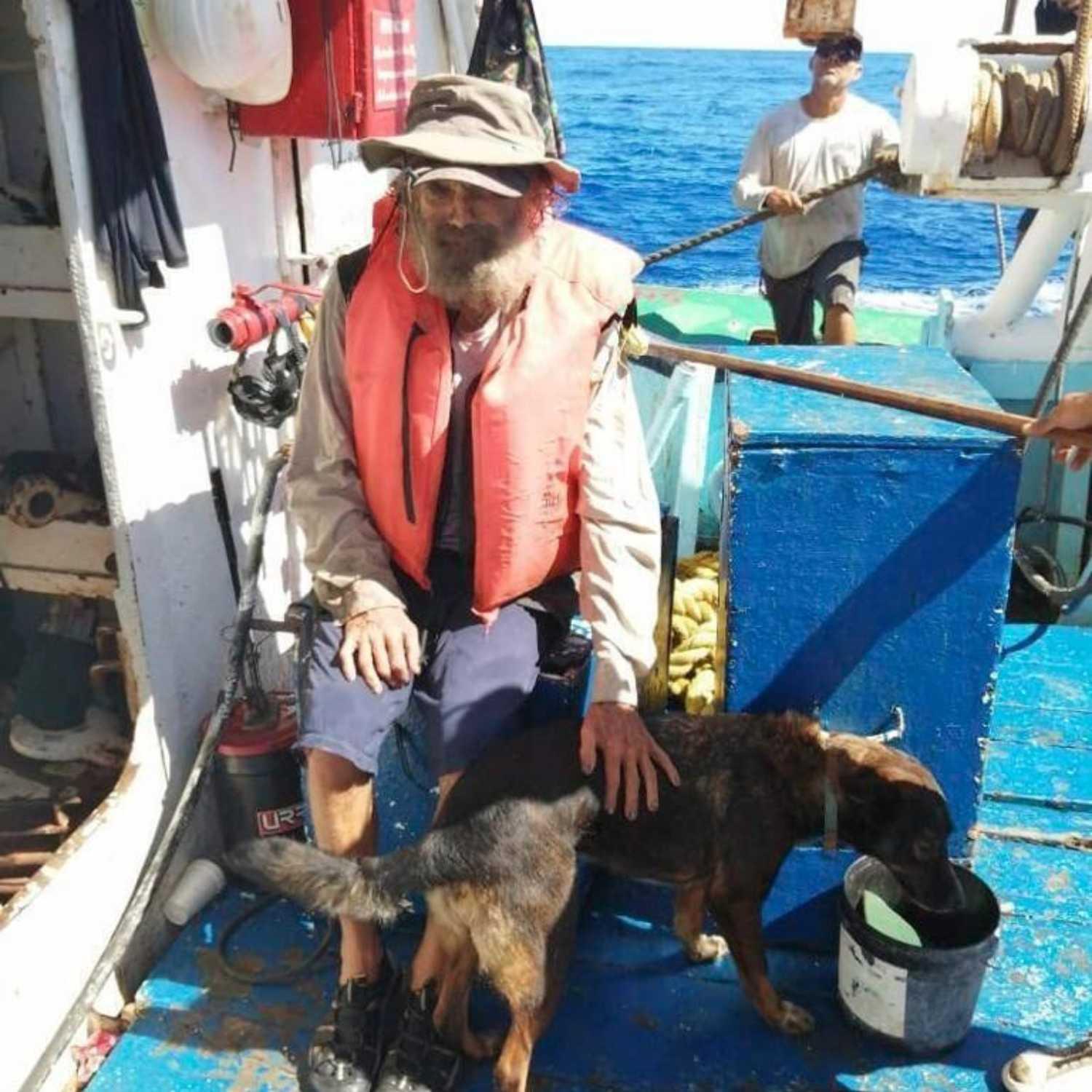 Tim Shaddock wearing a life jacket on a vessel with Bella beside him.