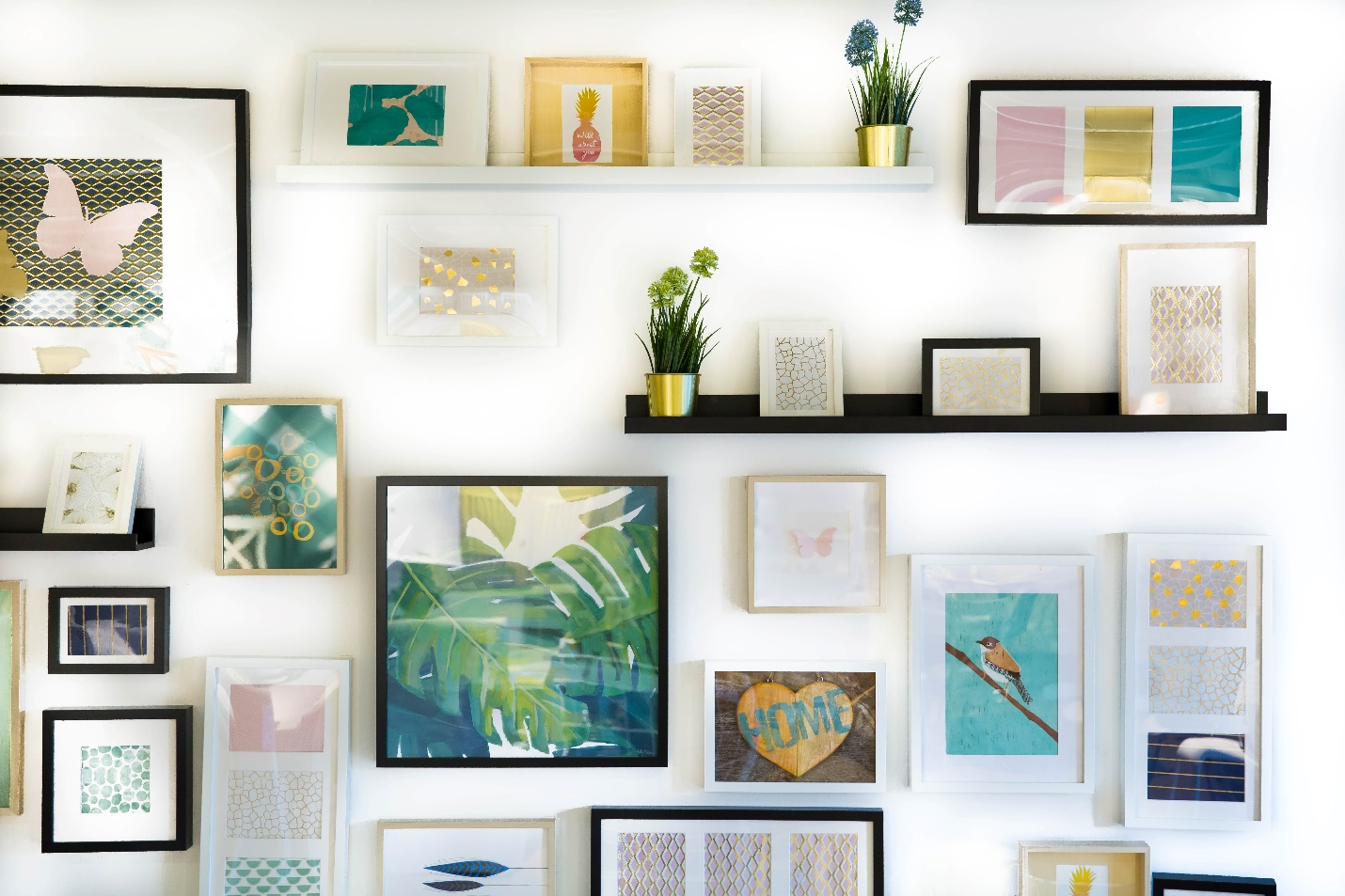 Framed pictures and small objects arranged on wall shelves
