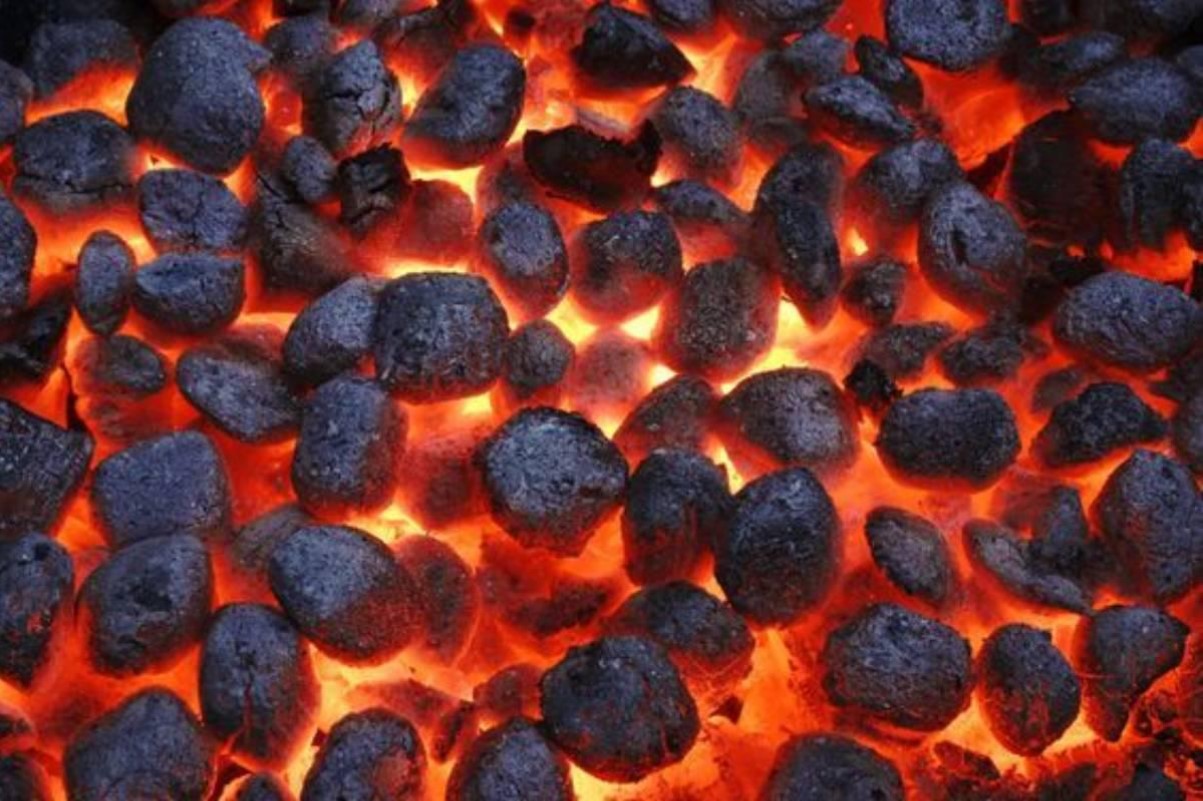 Glowing charcoal briquettes in a grill.