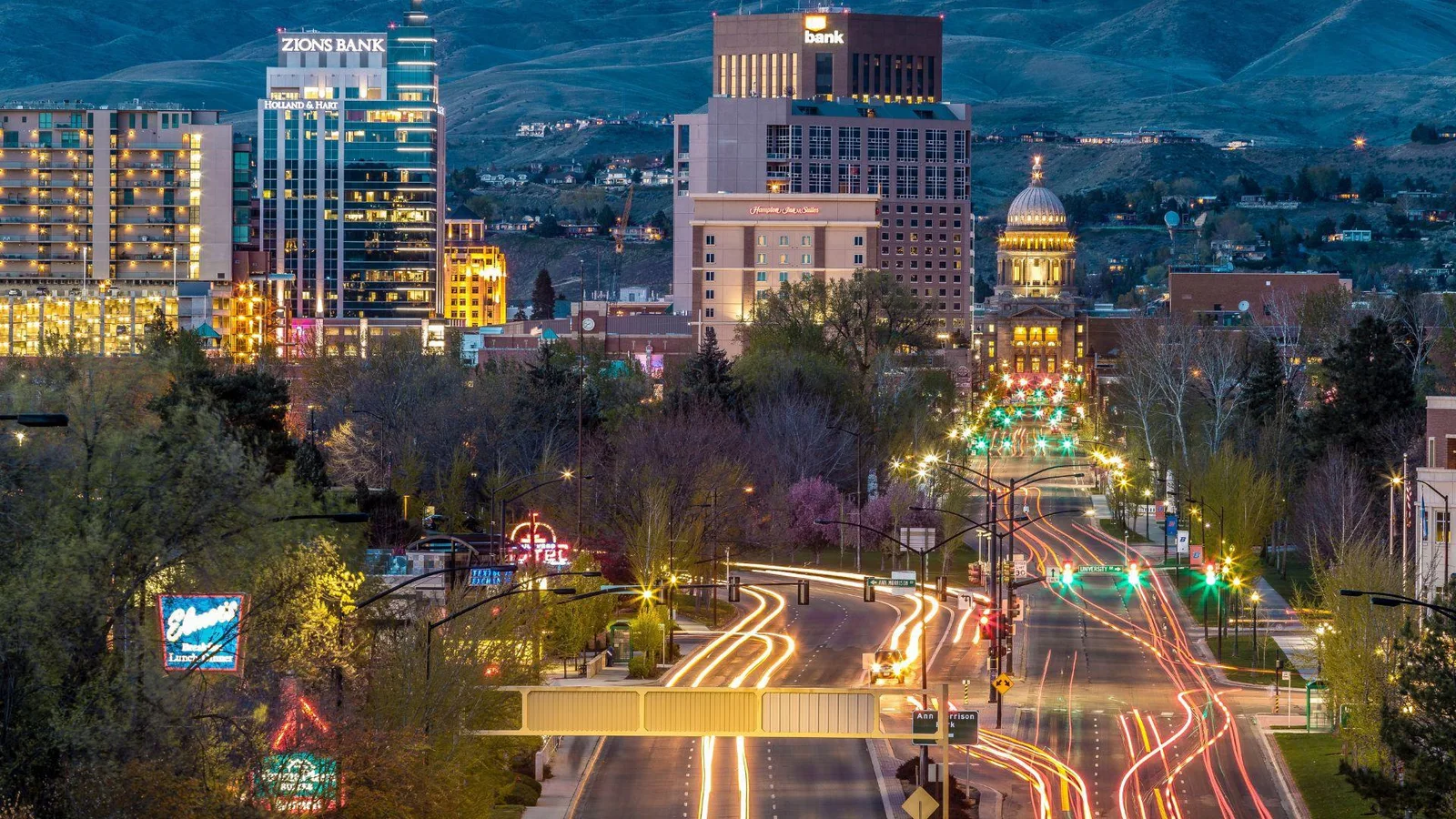 Twilight view over a bustling street in Boise, Idaho, with light trails from moving vehicles creating a vibrant scene