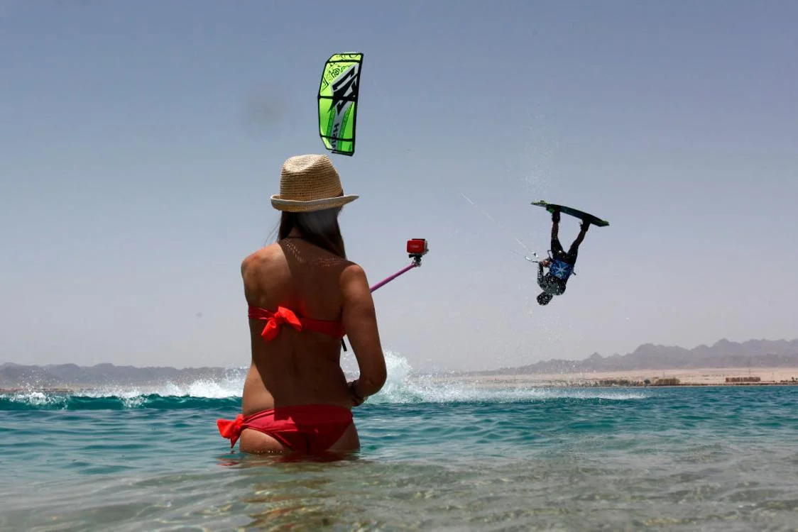 A Woman records her friend’s watersports routine with a GoPro
