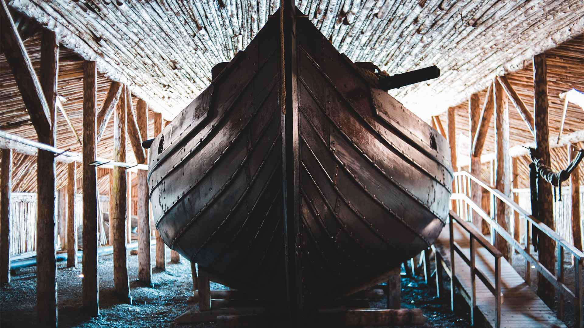 Illustrative photograph of a wooden boat inside a building.