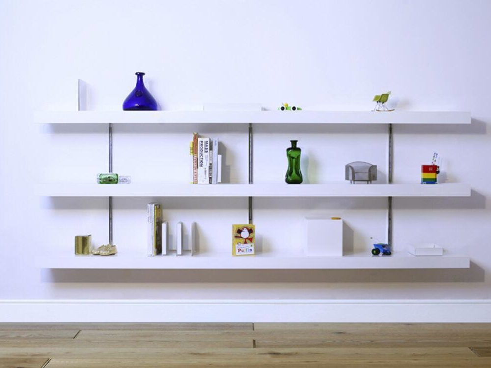 Long white wall shelves holding books and small decorative objects.
