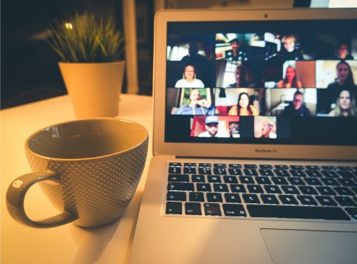 A laptop displaying a video meeting in an illustrative photograph