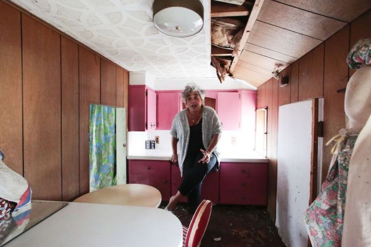 Anna Jones stooping inside a room in the miniature cottage.