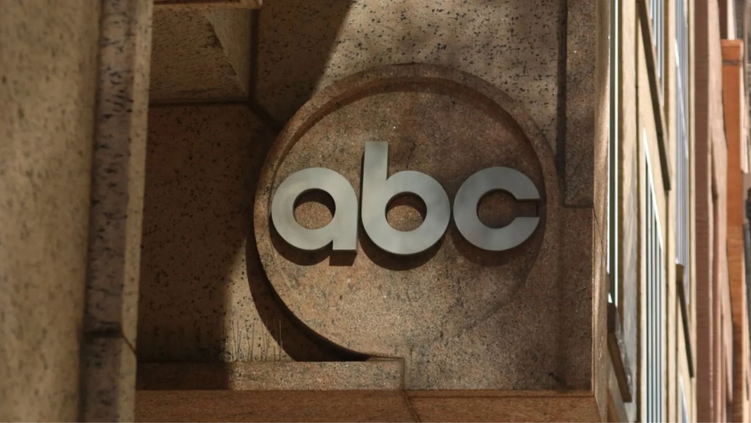 A photograph of the ABC network logo mounted on the exterior of a building