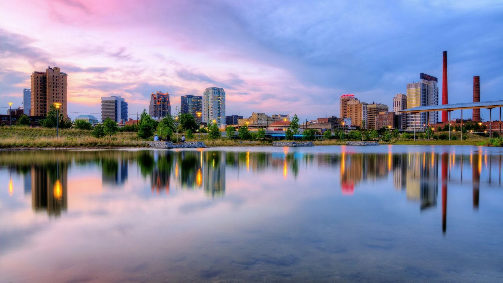A dusk scene of the Birmingham, Alabama skyline reflected in the waters of a river