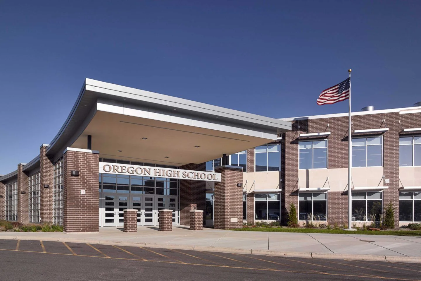 An image of Oregon High School, showcasing the brick exterior of the building, and the school’s name on a metal facade