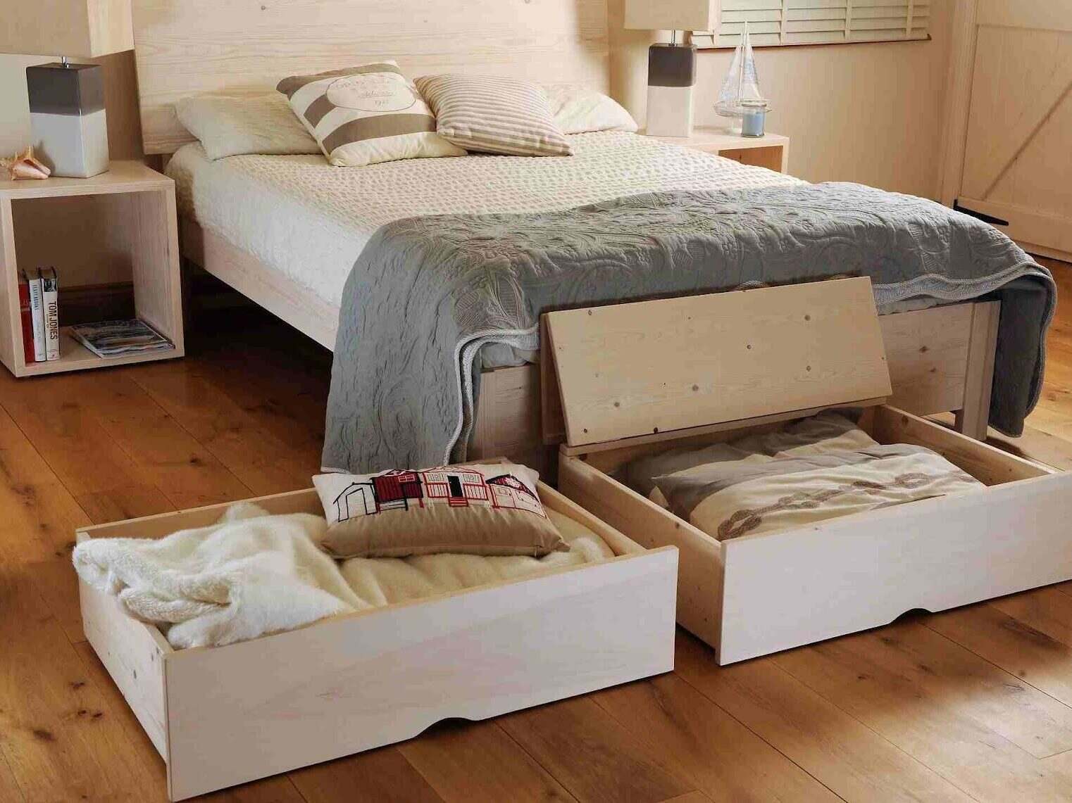 A bed with two under-bed drawers pulled open.