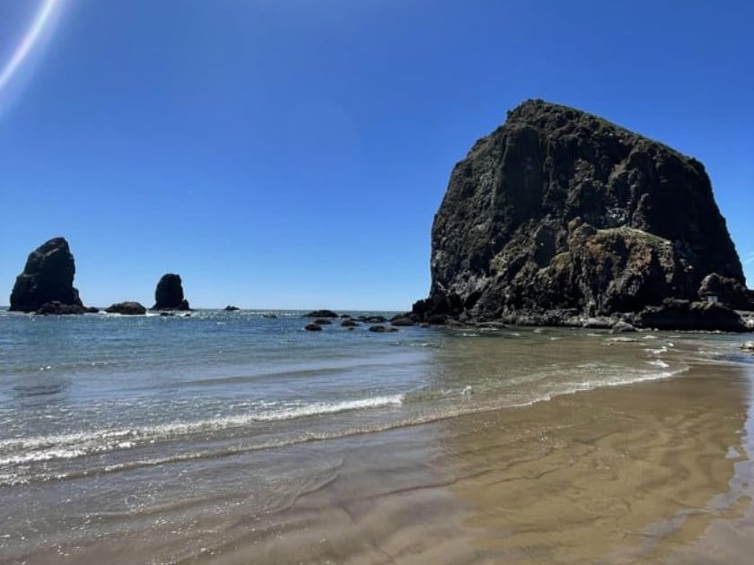 Archive photograph of Haystack Rock and nearby sea stacks from the beach.