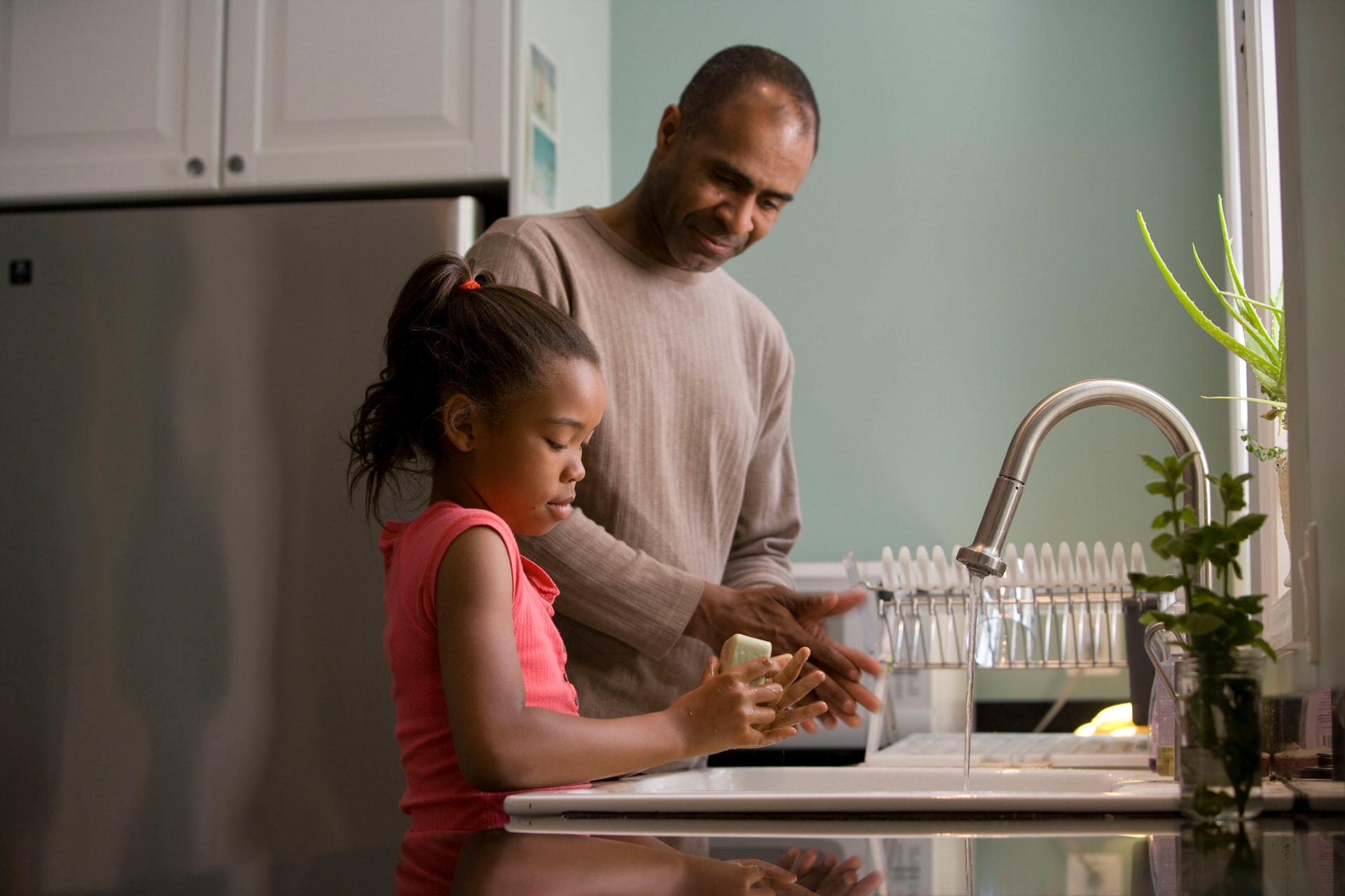 An adult and child preparing food at a kitchen counter