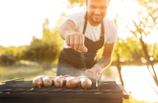 A person cooking food on an outdoor grill.