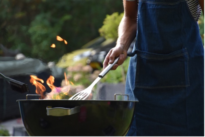 Person tending food on an outdoor grill