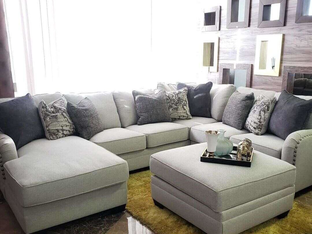 A grey sectional sofa arranged around a small table.
