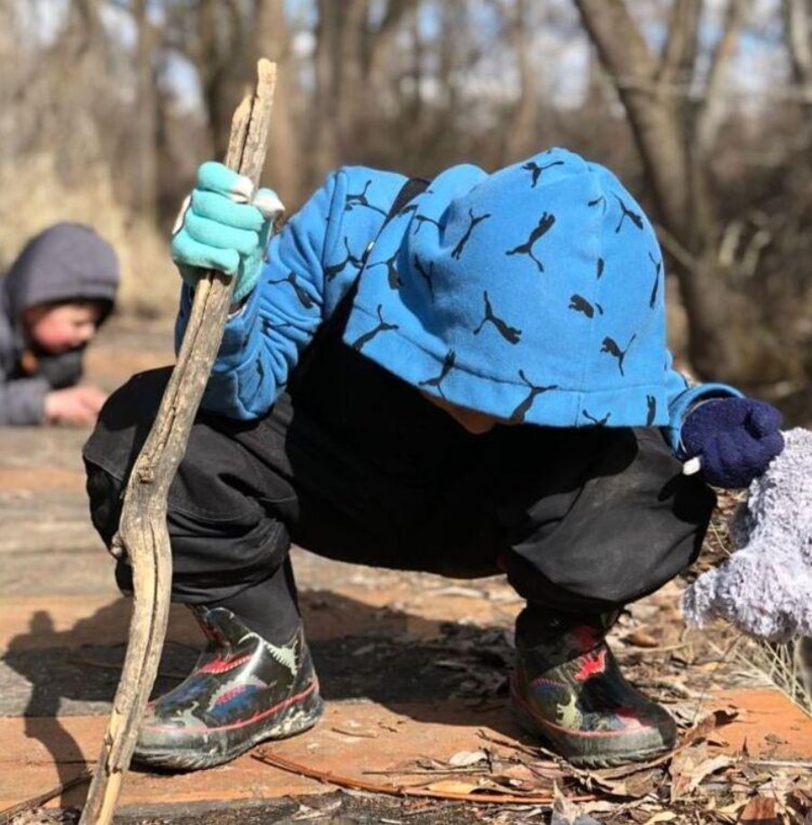 An illustrative archive photograph of a child wearing a blue backpack outdoors.