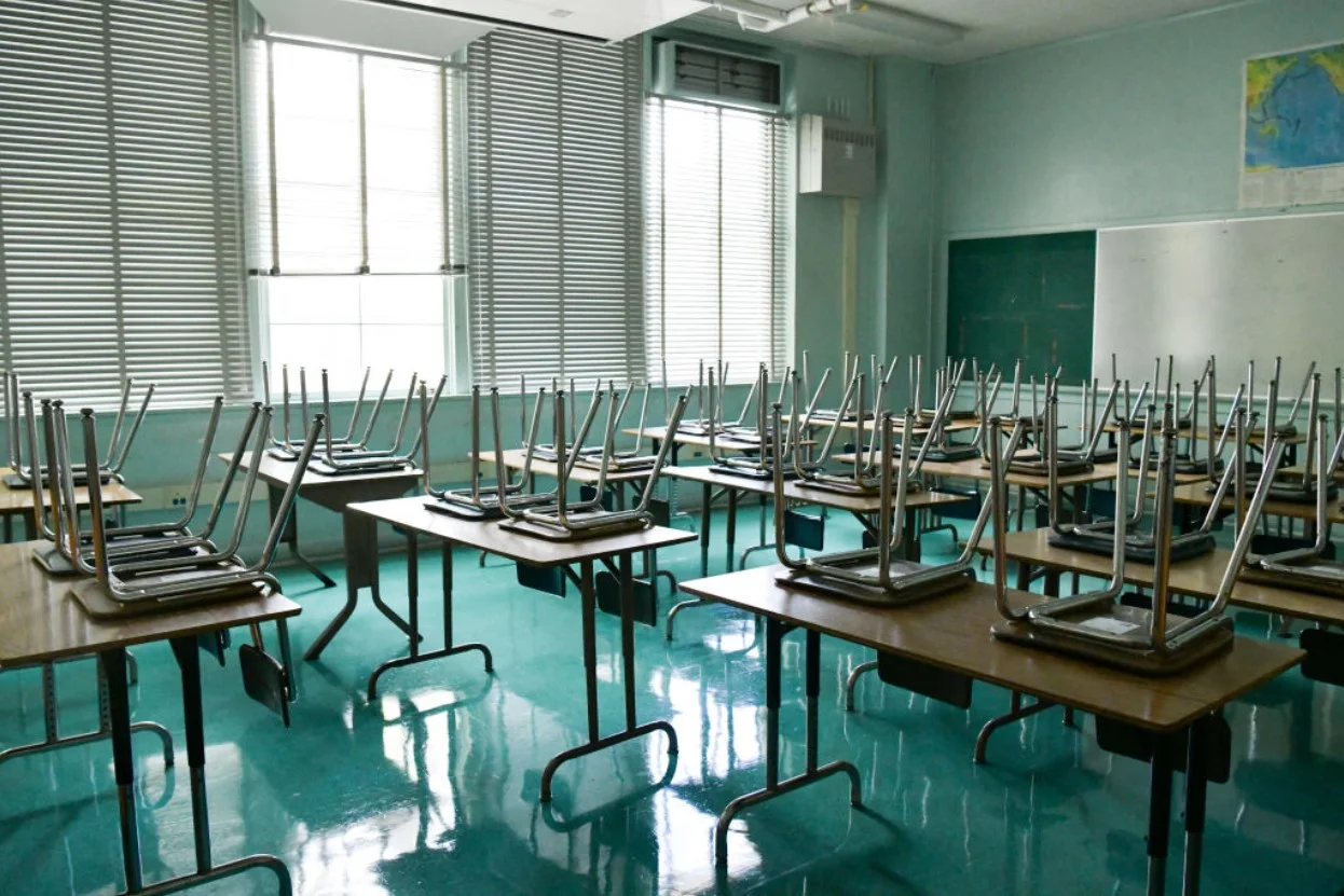 Empty classroom with chairs flipped onto the tables