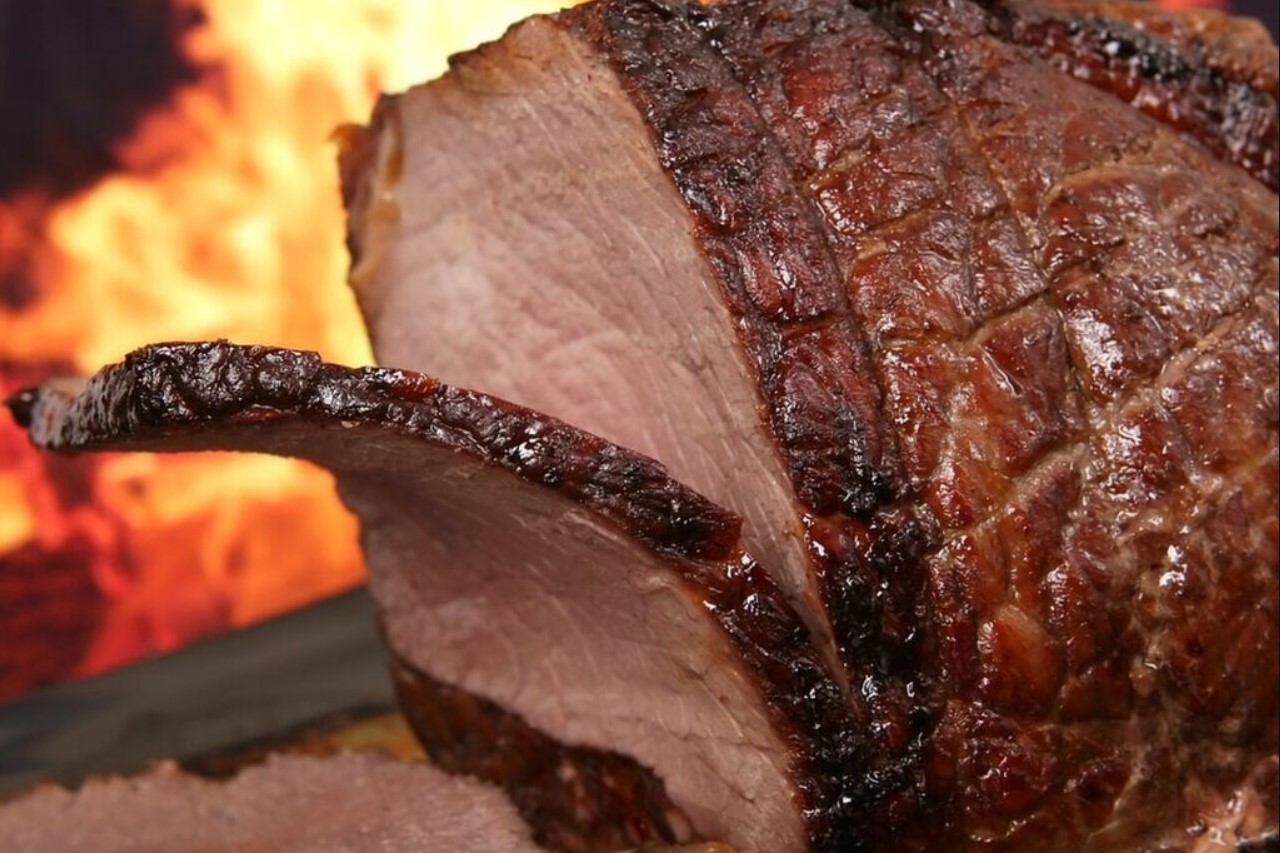 Sliced cooked meat with a knife beside it.