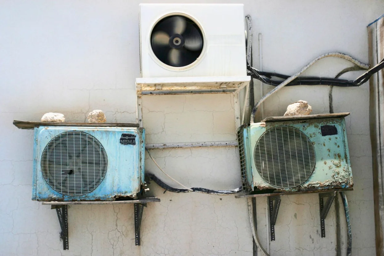 Old air conditioning units on the side of a building