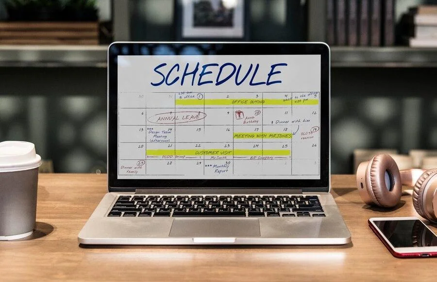 Open laptop on a table with a busy schedule on the screen
