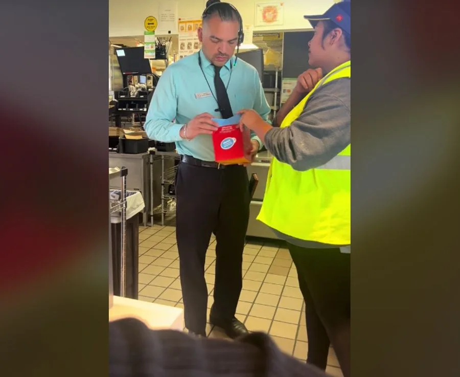 Mcdonald's manager inspects what’s inside of a returned Happy Meal